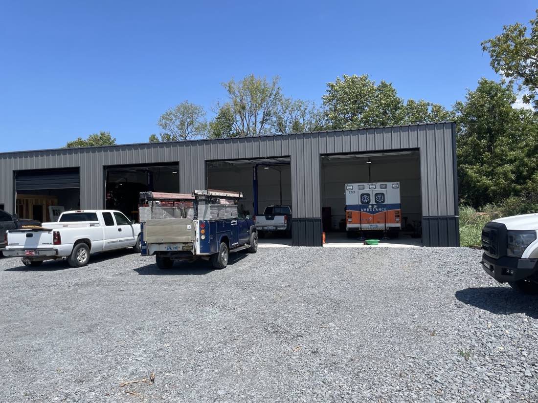 Reed Automotive shop building with three service bays and trucks in Ada, Oklahoma